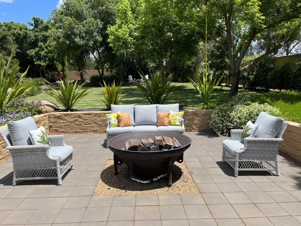 A patio with wicker furniture and a fire pit.