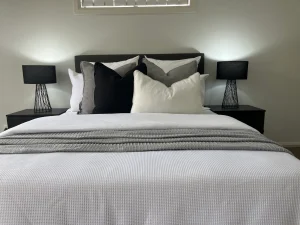 A bed with a white and black comforter and pillows.